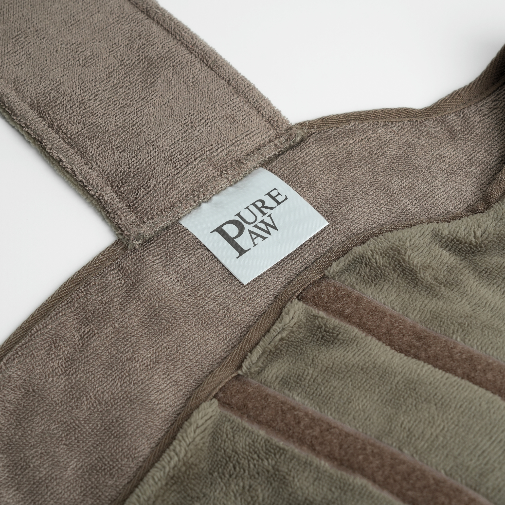 Bruine handdoek met 'PURE PAW'-label op een witte achtergrond