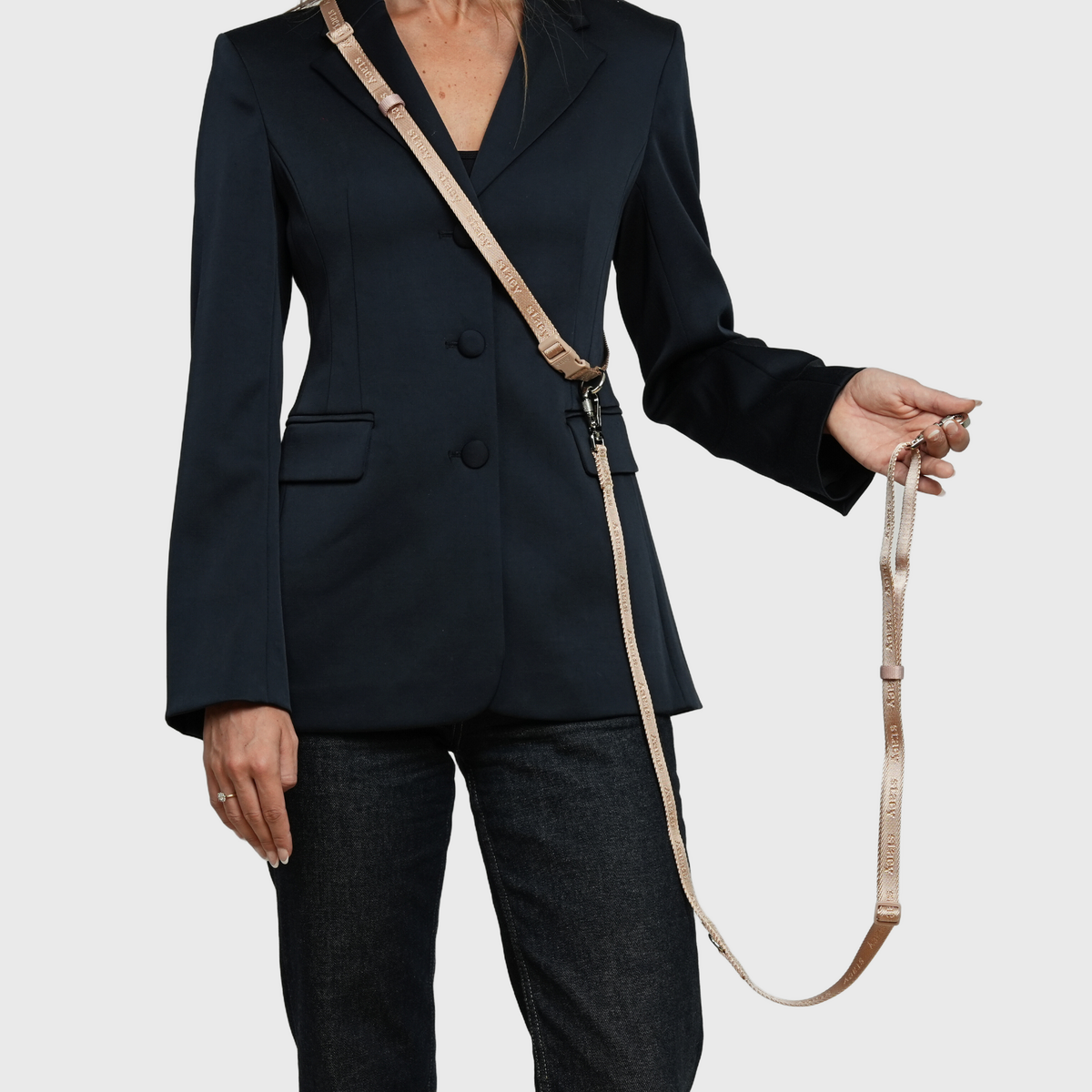 Woman holding the handle of the light rose hands-free leash