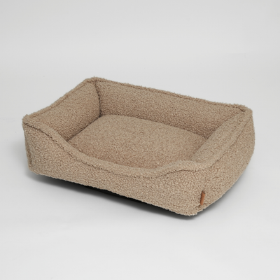 Tora dog bed in sand curly bouclé with a low bolster edge
