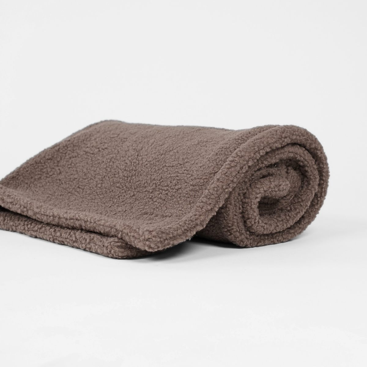 De taupe teddyhondendeken, opgerold
