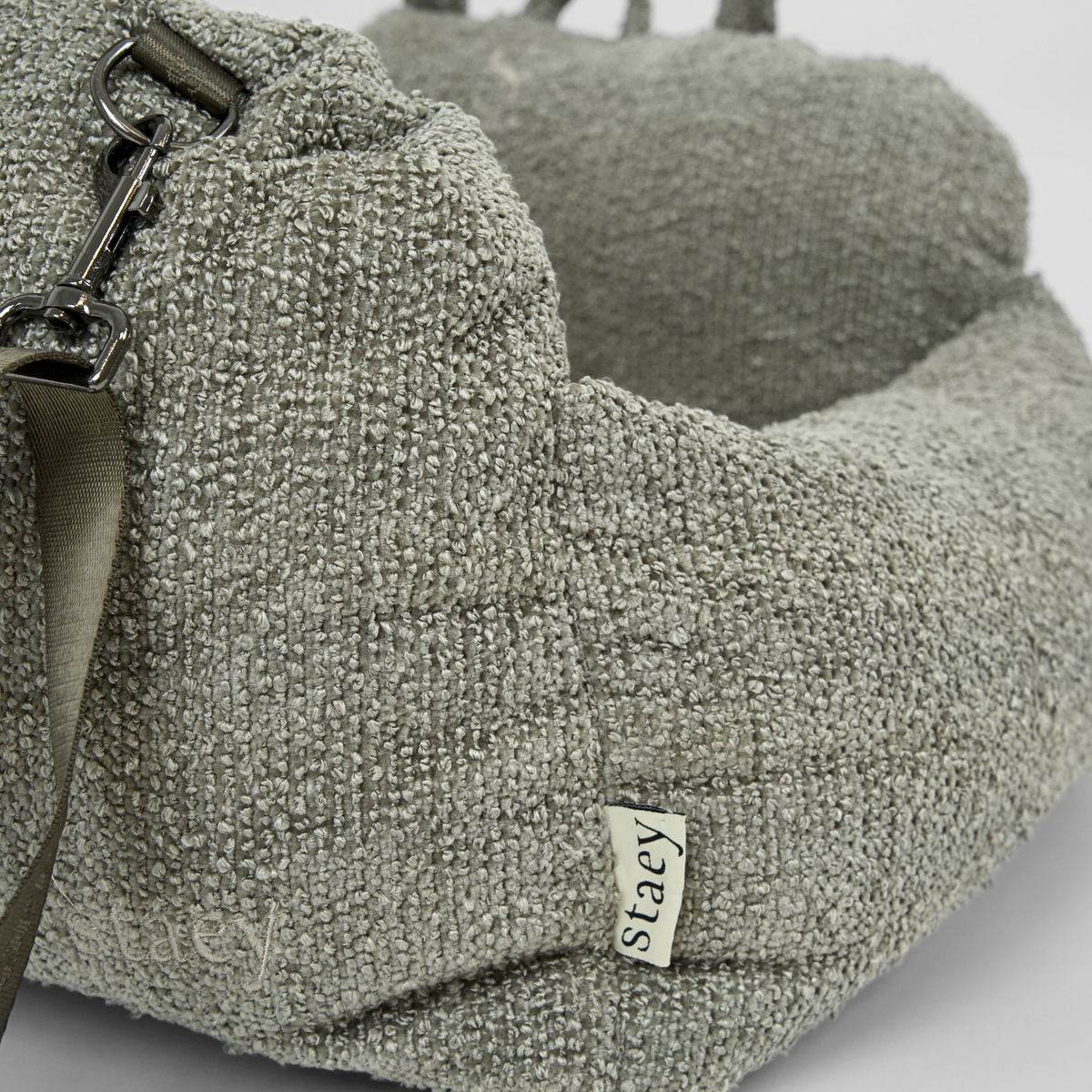 The moss green bouclé dog car seat with its Staey label and safety leash